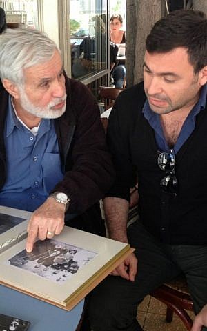 Moshe Zaki shows his son Uri Zaki a scrapbook with photos and articles about his mother Souad Zaki. (photo credit: Renee Ghert-Zand)